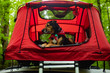 © Leann Weissmann/Scopio - A black and tan dog in a red ten on top of a car.