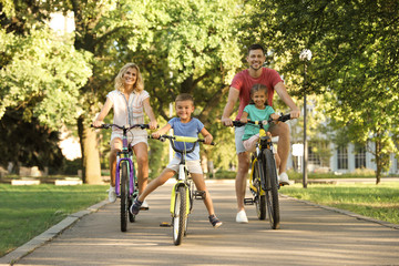 Canvas Print - Happy family with children riding bicycles in park