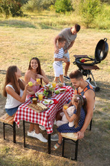 Wall Mural - Happy families with little children having picnic in park