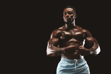 Wall Mural - Attractive african bodybuilder showing his athletic body