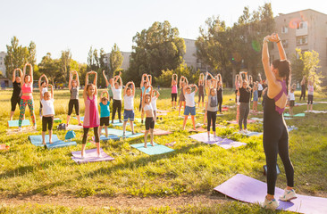 Wall Mural - children do yoga with an outdoor trainer.