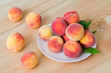 Wall Mural - Fresh organic peaches in a plate on a wooden table