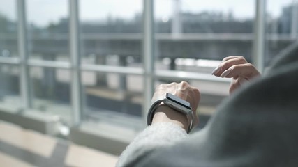 Woman using smartwatch touchscreen technology device. Smart watch on female wrist. Woman making gestures on a wearable smartwatch. Online banking. Lifestyle. Easy pay using digital device.