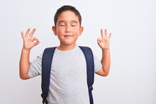 Beautiful Student Kid Boy Wearing Backpack Standing Over Isolated White Background Relax And Smiling With Eyes Closed Doing Meditation Gesture With Fingers. Yoga Concept.