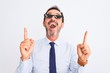 © Krakenimages.com - Middle age businessman wearing thug life sunglasses over isolated white background amazed and surprised looking up and pointing with fingers and raised arms.