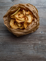 Wall Mural - Homemade dried organic apple sliced on wood background, healthy snack concept