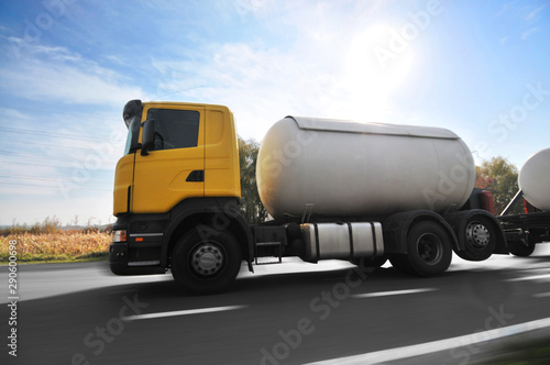 Fotomural Big metal fuel tanker truck shipping fuel on the countryside road in motion agai