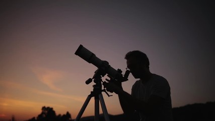 Wall Mural - astronomer with a telescope watching at the stars and moon. my astronomy work.