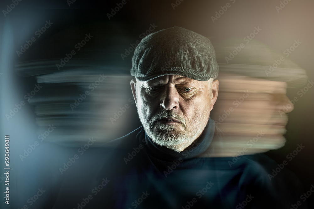 Portrait of a senior man with flat cap in front of black background. Ghostly faces surround him. Concept: surreal portrait - obrazy, fototapety, plakaty 