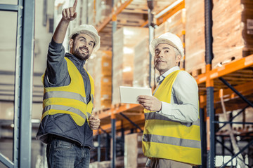 Wall Mural - Joyful young man listening to his colleague