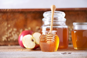 Apples with honey jar, honeycomb on grey background with copy space. Rosh hashanah jewish new year holiday celebration