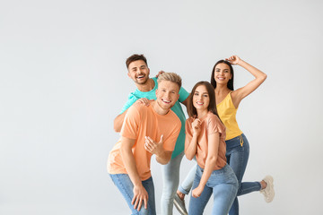 Wall Mural - Group of young people in stylish casual clothes on light background