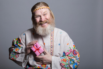 Slavic man in a beautiful shirt with a gift in his hands