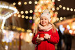 © Syda Productions - holidays, childhood and people concept - happy little girl with cup of tea at christmas market in winter evening