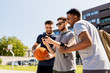 © Syda Productions - sport, leisure games and male friendship concept - group of men or friends with smartphone at outdoor basketball playground