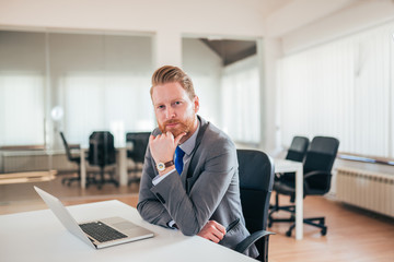 Wall Mural - Portrait of successful business man in bright office.