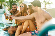 © Drobot Dean - Group of cheerful young friends sitting at the pool