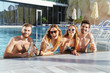© Drobot Dean - Group of cheerful young friends sitting at the pool