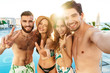 © Drobot Dean - Group of cheerful friends standing together at the poolside