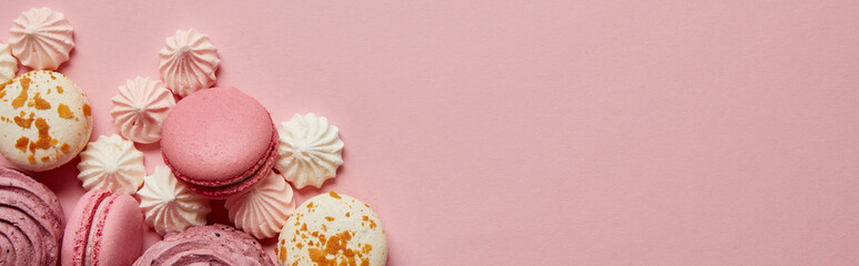 Wall Mural - Top view of gourmet pink macaroons, assorted meringues and soft zephyr on pink background