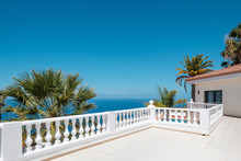 Villa With Ocean View Terrace, Blue Sky And Palm Tree Background