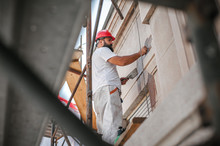 Man Worker Standing On Scaffolding And Restore Old Building Facade
