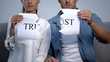 © motortion - Young couple tearing into pieces trust word on cardboard, misunderstanding