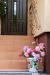 Piękna kolorowa dekoracja z kolorowych kwiatów i wiaderka na schodach domu.	
