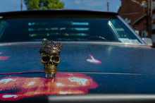 WROCLAW, POLAND - August 11, 2019: USA Cars Show - Metallic  Skull With A Crown On The Hood Of The Car Cadillac DeVille. Close-up.