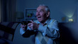 © motortion - Extremely happy old man holding joystick, celebrating video game victory, fun