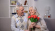 © motortion - Elderly man hugging happy woman with bunch tulips, present greeting, attention