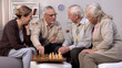 © motortion - Happy retired people playing chess in nursing home together, pension free time