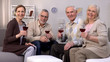 © motortion - Aged men and women holding wine glasses smiling camera, friends togetherness