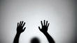 Silhouette of hands sliding down glass wall, person dying, crime scene, horror