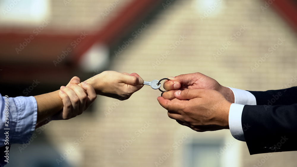 Man and woman pulling key from house, division of property after divorce closeup - obrazy, fototapety, plakaty 