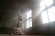 © Hladchenko Viktor - Male duo making acrobatic tricks wearing costume of insane people in abandoned room with sun rays from windows