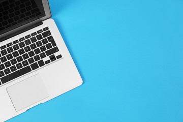 Modern laptop on blue background, top view. Space for text
