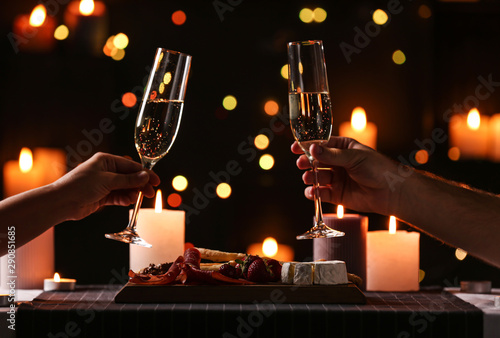 Fotografía Young couple with glasses of champagne having romantic candlelight dinner at tab