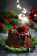 Christmas Chocolate Bundt Cake With Glaze Decorated With Fresh Berries And Rosemary. Winter Baking At Xmas Or New Year With Decorations On Dark Background