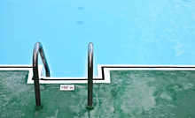 Edge Of A Small Swimming Pool With A Depth Marker And A Steel Ladder, Blots From Chlorinated Water, Low Saturation Image With Flat Light Processing.