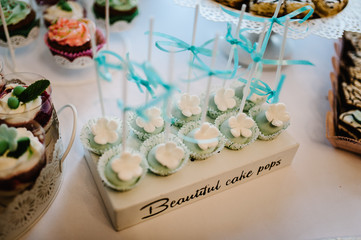 Wall Mural - Colorful table with sweets and goodies for the wedding party reception, decorated dessert table. Delicious sweets on candy buffet. Dessert table for a party. cakes, cupcakes. Beautiful cake pops.