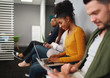© StratfordProductions - Concentrated smiling young african american woman sitting in queue preparing for job talk hiring in office