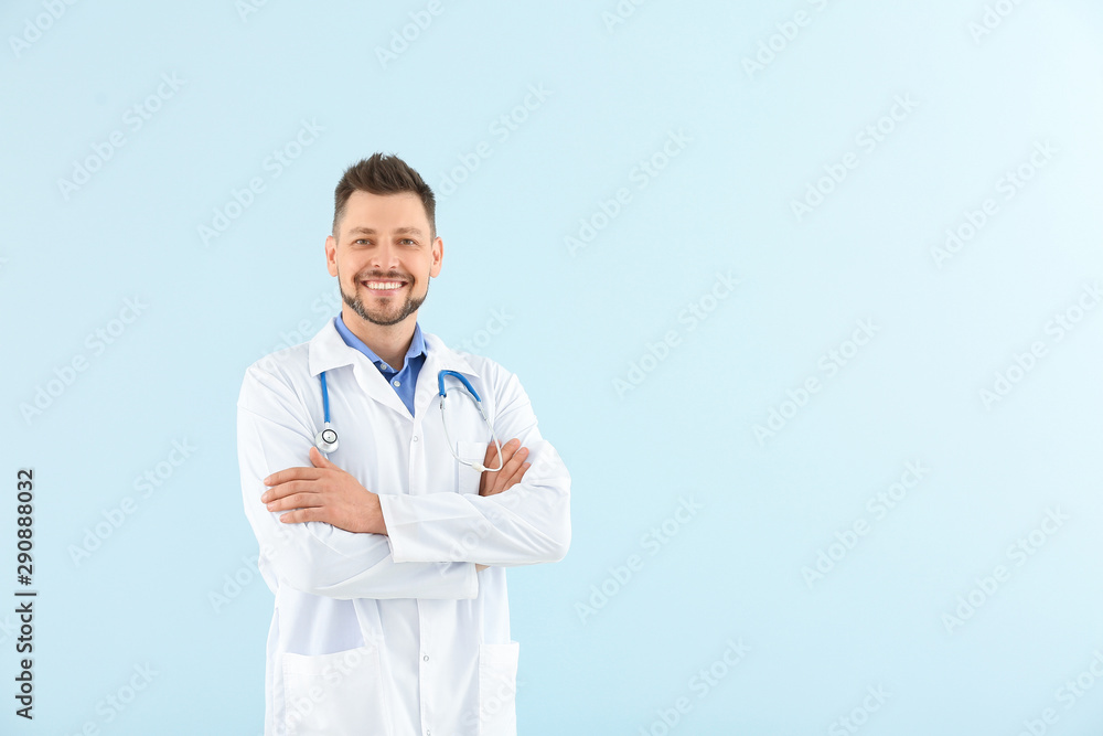 Male doctor with stethoscope on light color background