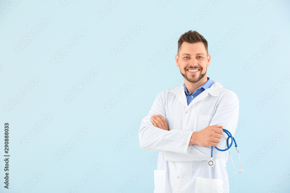 Male doctor with stethoscope on light color background
