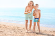 © Pixel-Shot - Happy man with his son showing thumb-up on sea beach