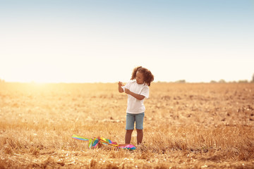 Wall Mural - Little African-American girl flying kite outdoors