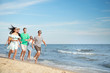 © Pixel-Shot - Happy friends running on sea beach at resort