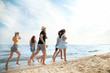 © Pixel-Shot - Happy friends running on sea beach at resort