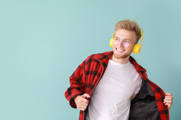 Sticker - Handsome young man listening to music on color background