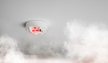 Close-up Of Smoke Alarm Or Smoke Detector In Home Going Off With Thick Smoke